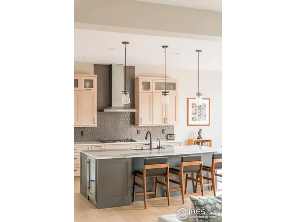 a kitchen with stainless steel appliances kitchen island granite countertop a dining table chairs and granite counter tops