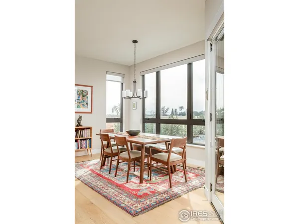 a dining room with furniture a chandelier and wooden floor