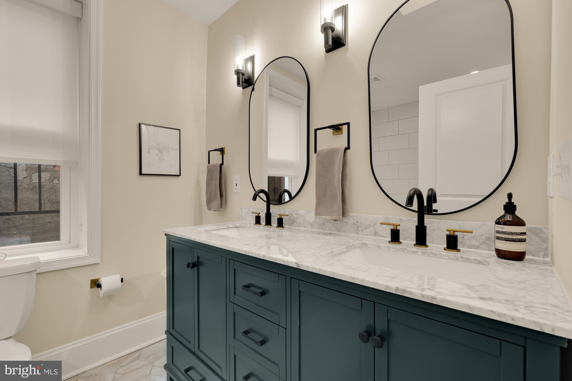 2208 East Baltimore Street Baltimore, MD 21231 - Photo 24 of 46 a bathroom with a double vanity sink and a mirror