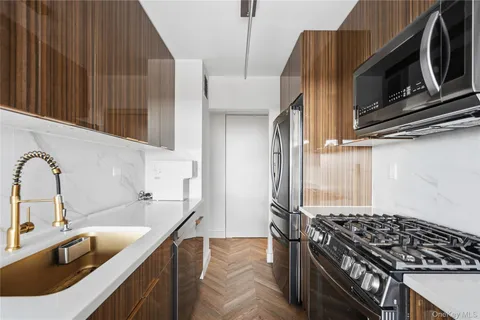 a kitchen with a sink a stove and cabinets