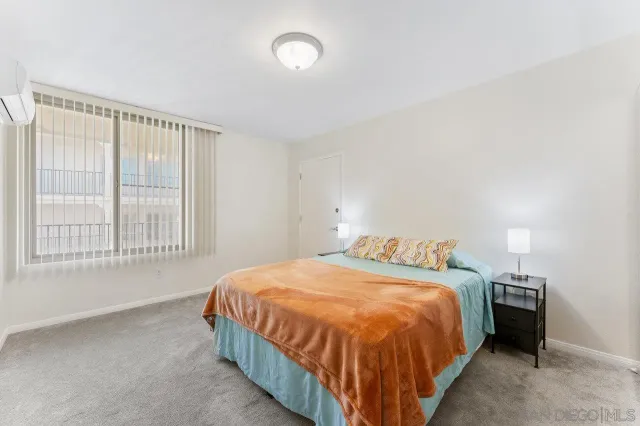 a bedroom with a bed and a large window