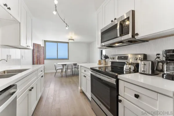 a kitchen with stainless steel appliances granite countertop a sink a stove oven a counter space and cabinets