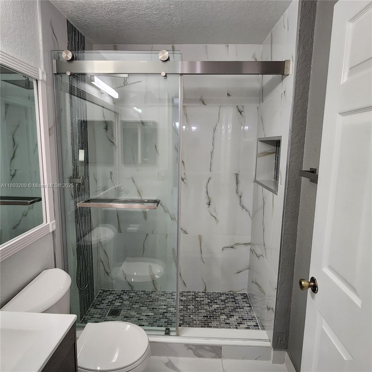 2941 Riverside Drive, Unit 102 Coral Springs, FL 33065 - Photo 15 of 37 a bathroom with a granite countertop shower a toilet and a sink