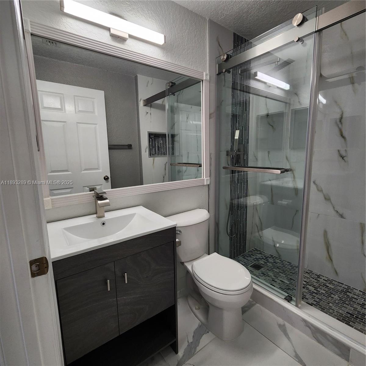 2941 Riverside Drive, Unit 102 Coral Springs, FL 33065 - Photo 18 of 37 a bathroom with a sink a toilet and shower