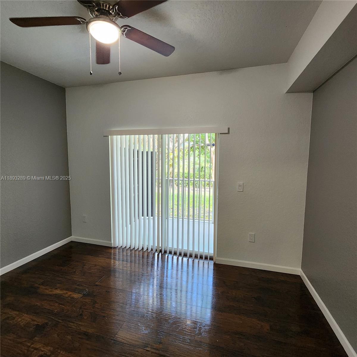 2941 Riverside Drive, Unit 102 Coral Springs, FL 33065 - Photo 22 of 37 an empty room with wooden floor and windows