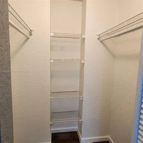 a view of walk in closet with empty racks