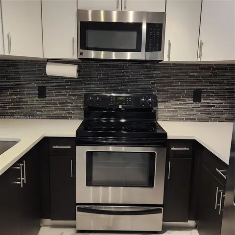a kitchen with granite countertop stainless steel appliances and cabinets