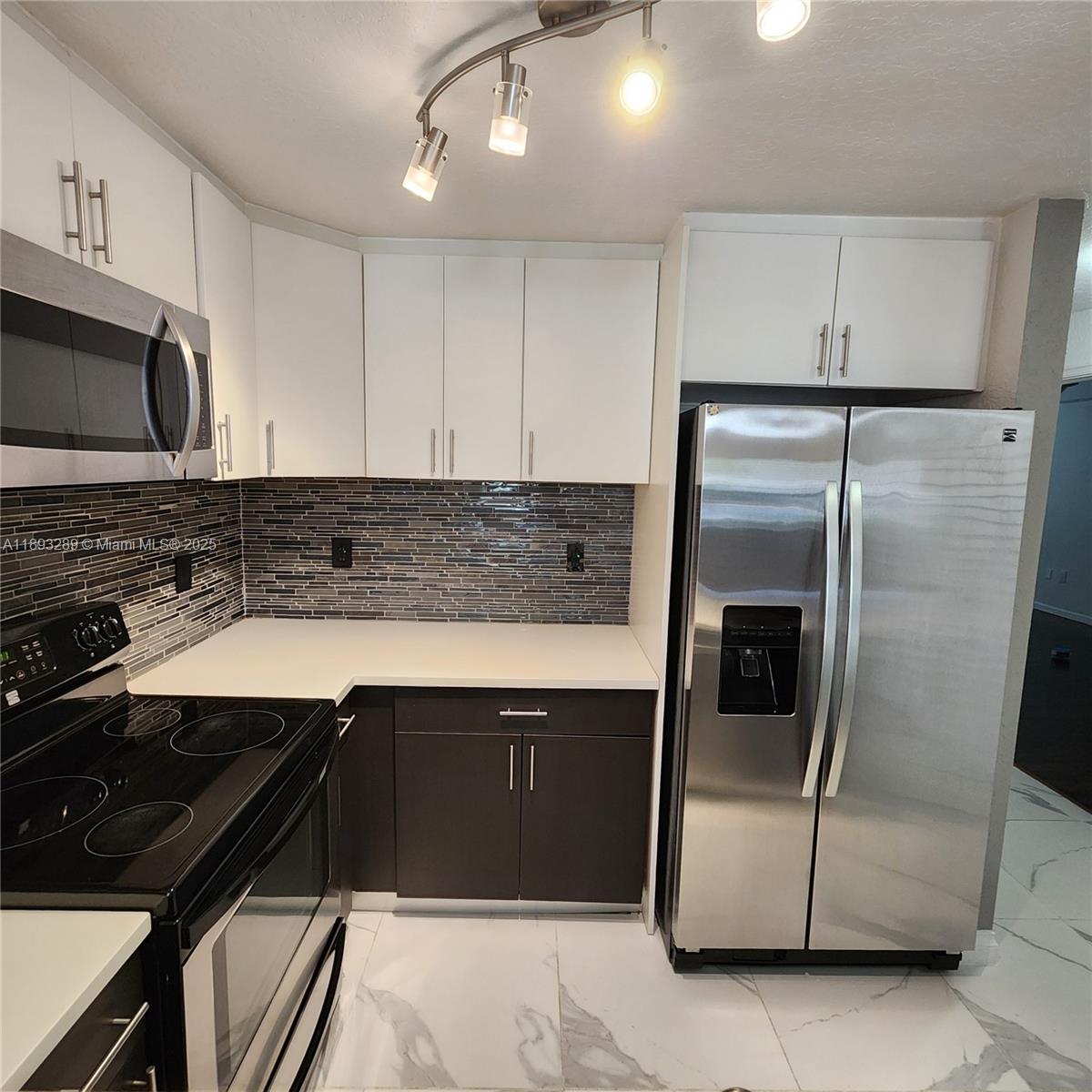 2941 Riverside Drive, Unit 102 Coral Springs, FL 33065 - Photo 10 of 37 a kitchen with a sink stainless steel appliances and cabinets