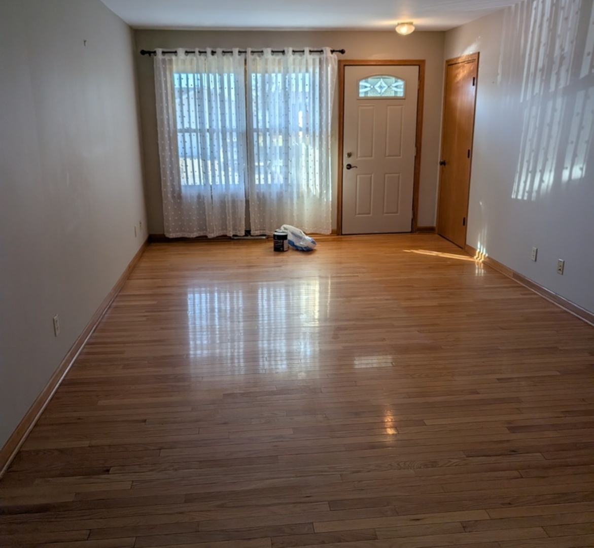 112 Wright Drive Utica, IL 61373 - Photo 3 of 30 an empty room with wooden floor and windows