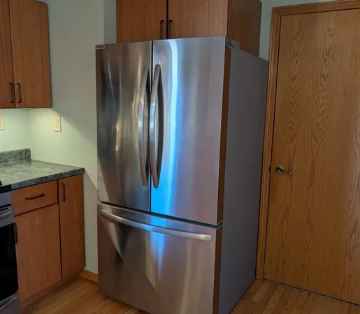 a metallic refrigerator freezer sitting in a kitchen