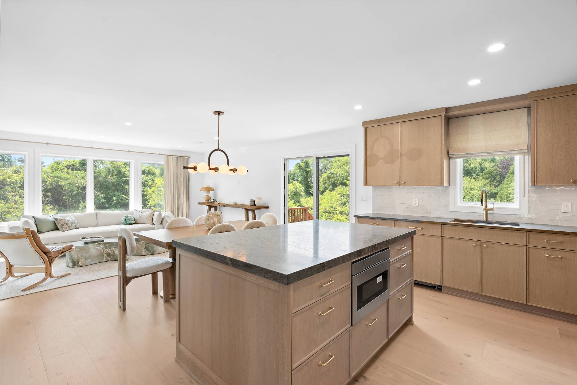 55 Fairview Avenue Montauk, NY 11954 - Photo 6 of 22 a kitchen with kitchen island granite countertop a sink and white cabinets
