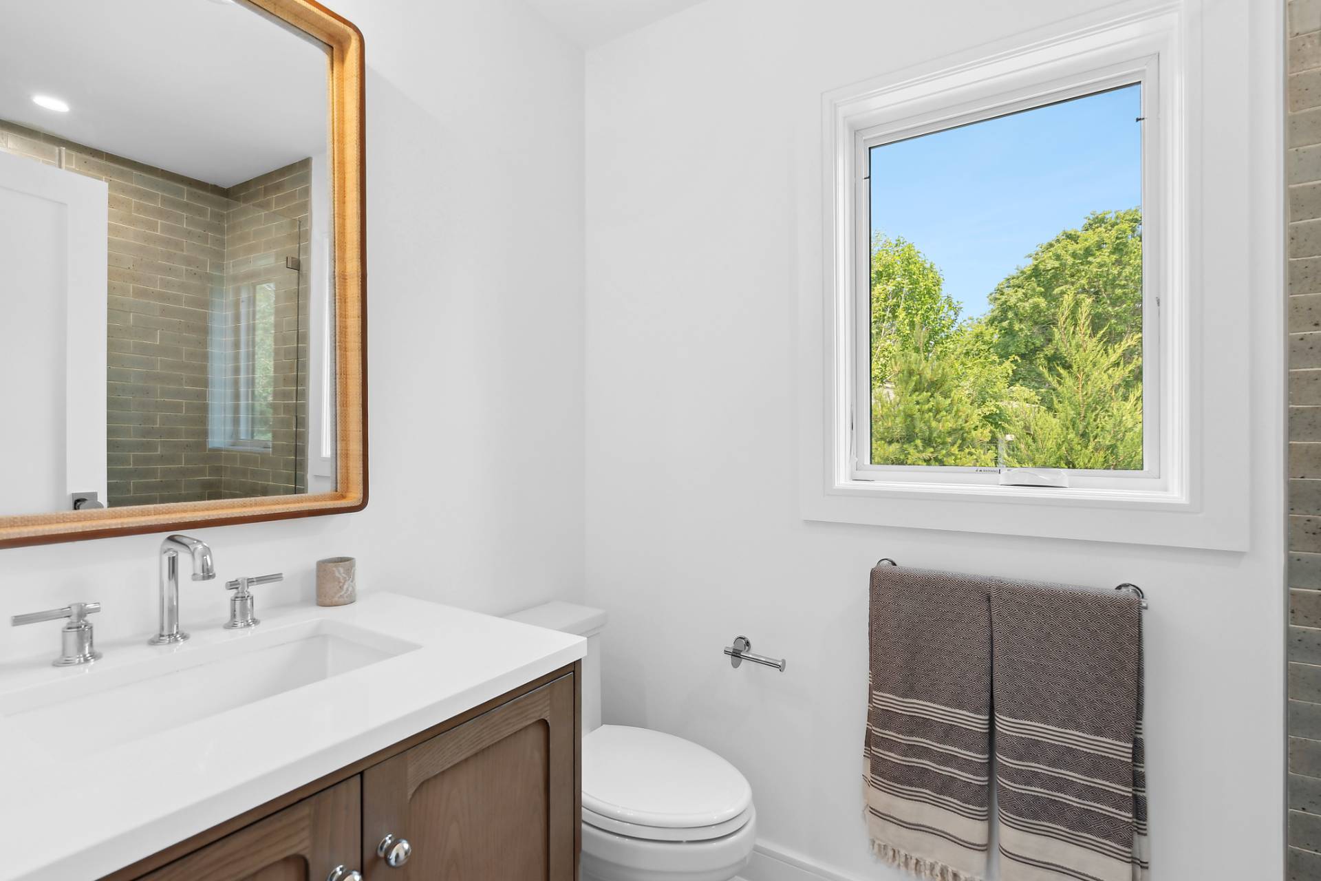 55 Fairview Avenue Montauk, NY 11954 - Photo 10 of 22 a bathroom with a toilet a sink a vanity and mirror