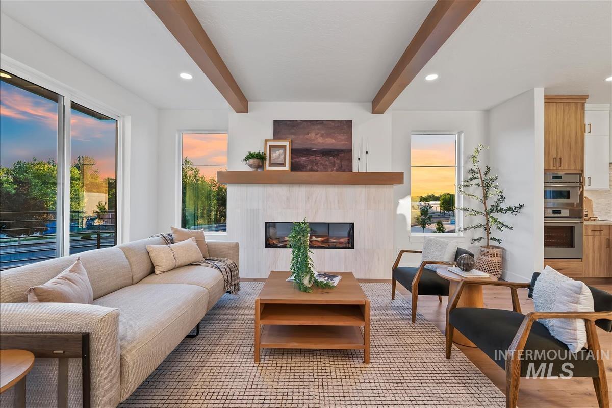 3219 West Moore Street Boise, ID 83702 - Photo 7 of 36 Living area featuring a modern fireplace with a light-colored tile surround and a wood mantel