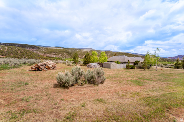 7343 North Sawtooth Cv Road Vernal, UT 84078 - Photo 45 of 64 Expansive property featuring a single-story residence with a composite shingle roof, a privacy fence, and multiple exterior sheds