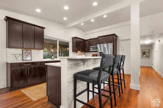 8678 Mount Majestic Road Sandy, UT 84093 - Photo 12 of 37 Kitchen featuring dark wood-finish cabinetry, white countertops, tile backsplash, and stainless steel appliances