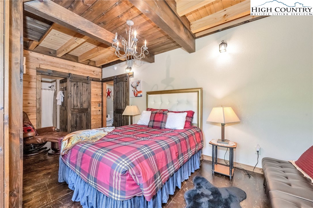 218 Cherokee Circle Jefferson, NC 28640 - Photo 27 of 50 a bedroom with a bed and a chandelier