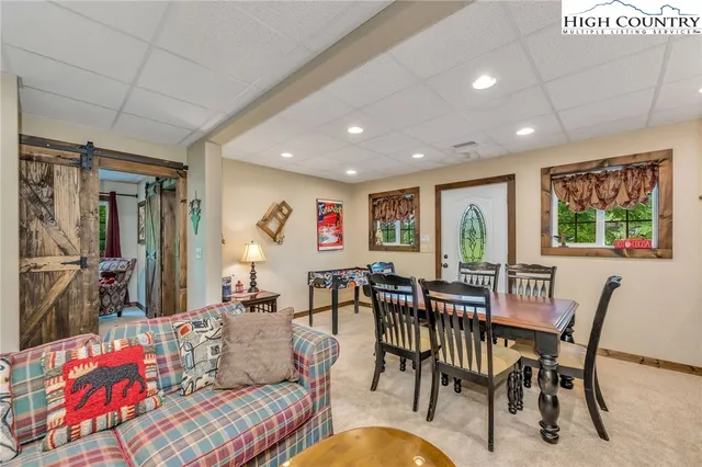 a living room with furniture a flat screen tv and a floor to ceiling window