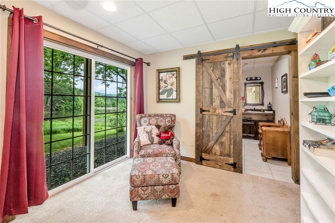 218 Cherokee Circle Jefferson, NC 28640 - Photo 43 of 50 a living room with furniture a flat screen tv and a floor to ceiling window