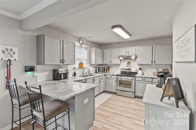 a kitchen with cabinets appliances and a dining table