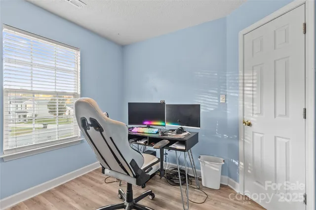 a view of a workspace with furniture and a window
