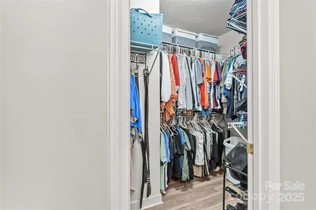 a view of walk in closet with clothes