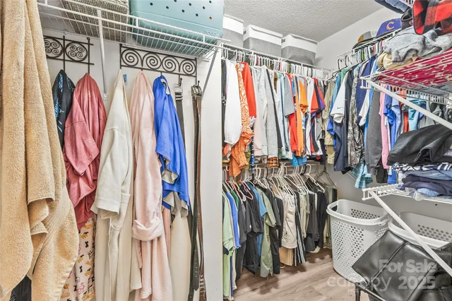 a view of walk in closet with clothes