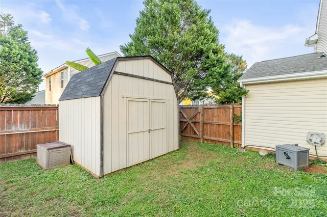 a view of backyard with barbeque and wooden fence