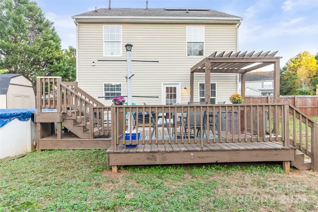 a view of a house with wooden deck and furniture