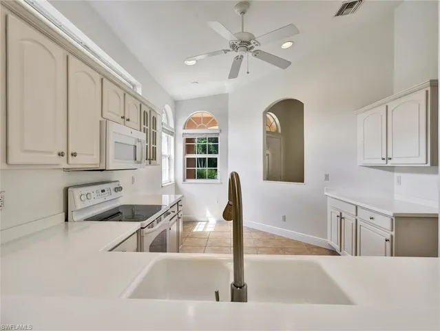 a kitchen with stainless steel appliances granite countertop a sink and a white cabinets