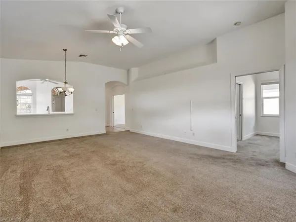 a view of a big room with chandelier fan and windows