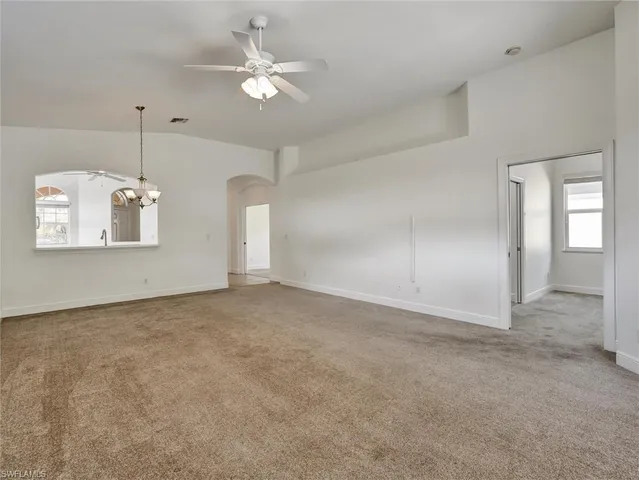 a view of a big room with chandelier fan and windows