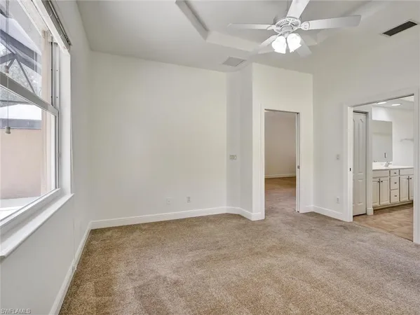an empty room with a ceiling fan and a window