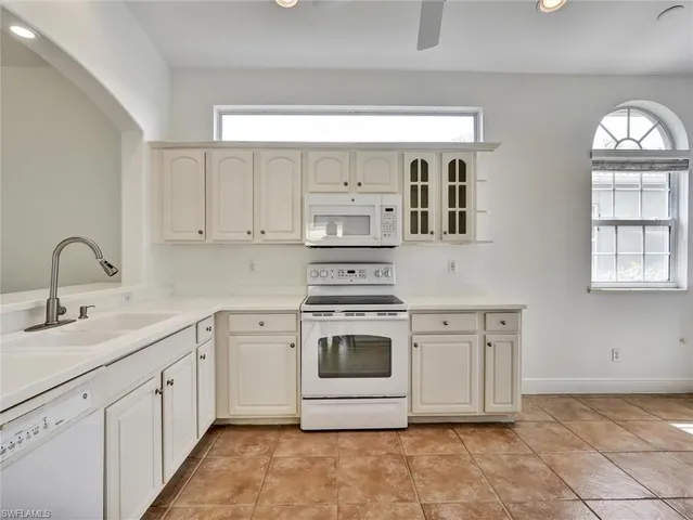 a kitchen with stainless steel appliances granite countertop a stove a sink and white cabinets