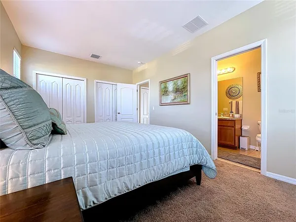 a spacious bedroom with a bed and painting on the wall