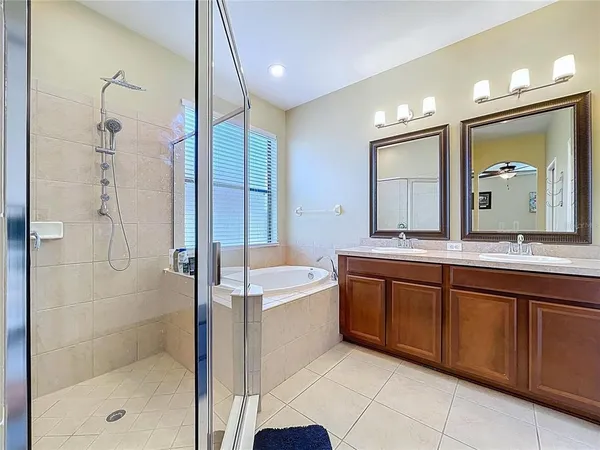 a spacious bathroom with a double vanity sink a large mirror and shower