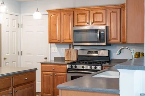 a kitchen with granite countertop a stove top oven microwave and cabinets