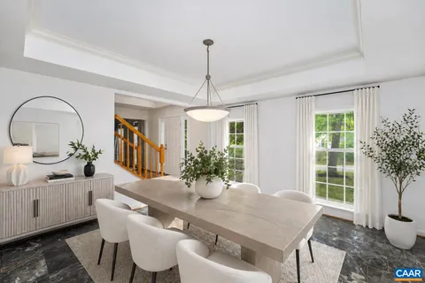 a dining room with furniture potted plants and wooden floor