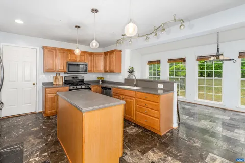 a kitchen with stainless steel appliances granite countertop a sink a stove and a refrigerator