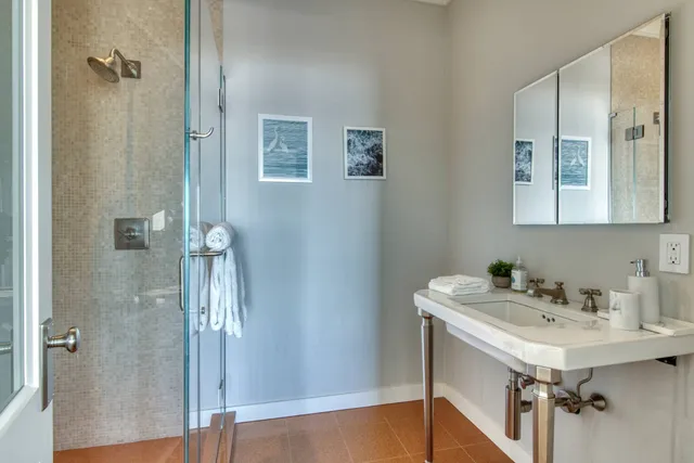a bathroom with a sink mirror and a shower
