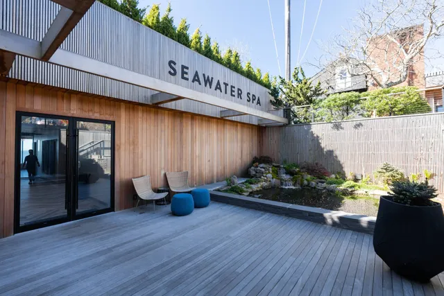 a front view of a house with lots of plants and seating space