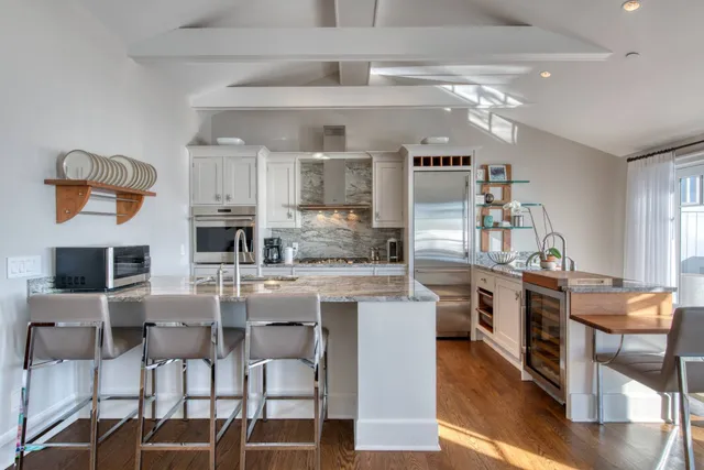 a kitchen with stainless steel appliances kitchen island granite countertop a table and chairs in it