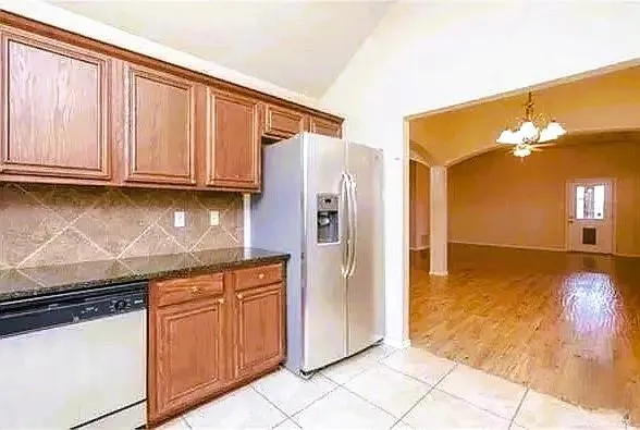 a kitchen with granite countertop a refrigerator and a sink