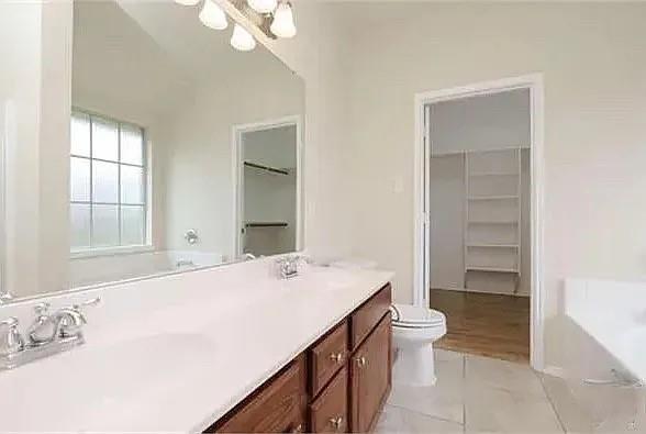 1012 Raleigh Path Denton, TX 76208 - Photo 5 of 9 a spacious bathroom with a granite countertop sink a toilet and a bathtub
