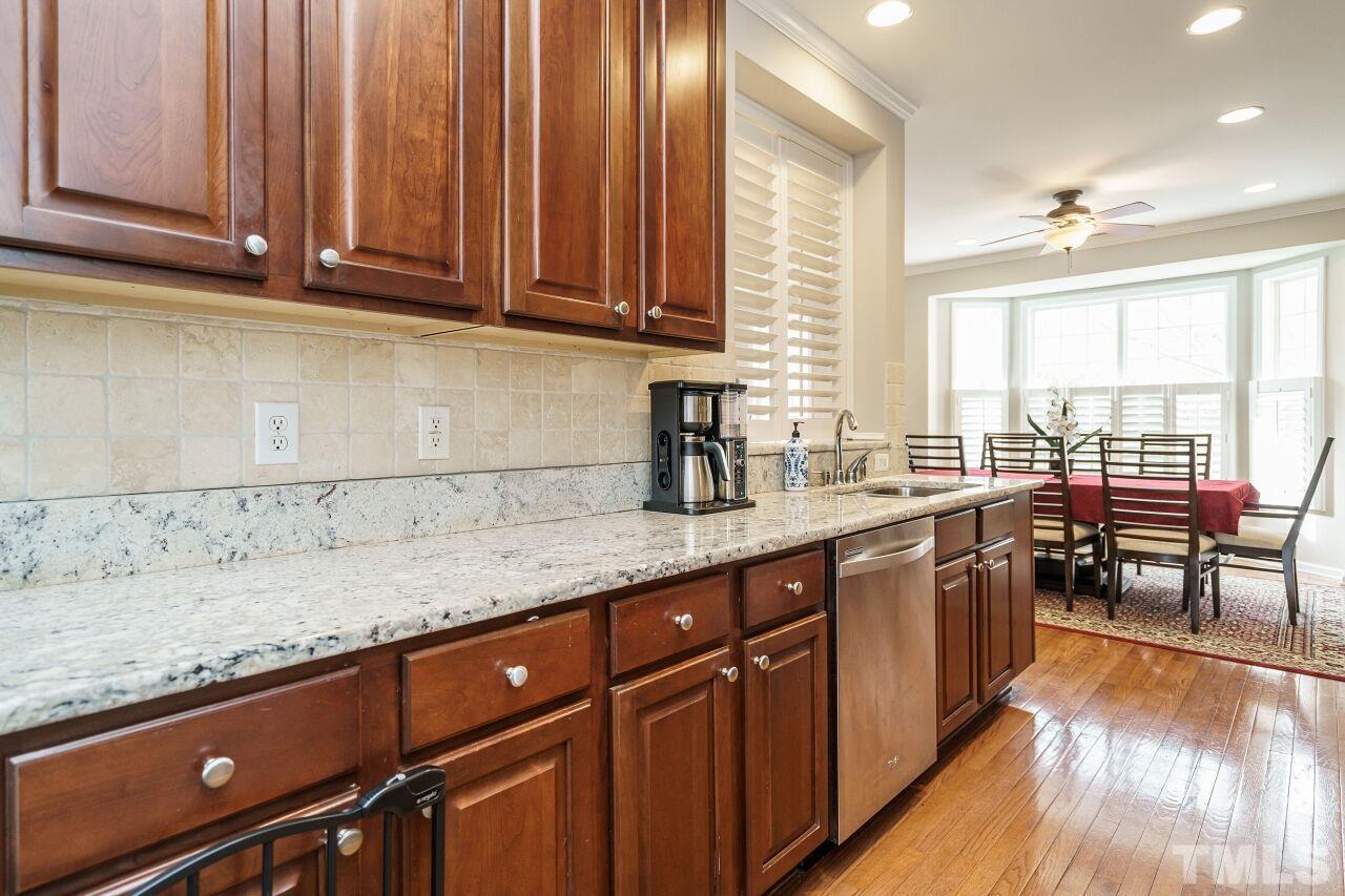 6903 Middleboro Drive Raleigh, NC 27612 - Photo 11 of 26 a kitchen with stainless steel appliances granite countertop wooden cabinets a sink and dishwasher