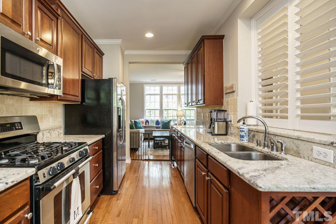 6903 Middleboro Drive Raleigh, NC 27612 - Photo 14 of 26 a kitchen with stainless steel appliances granite countertop a stove a sink dishwasher a refrigerator and a microwave oven with wooden floor