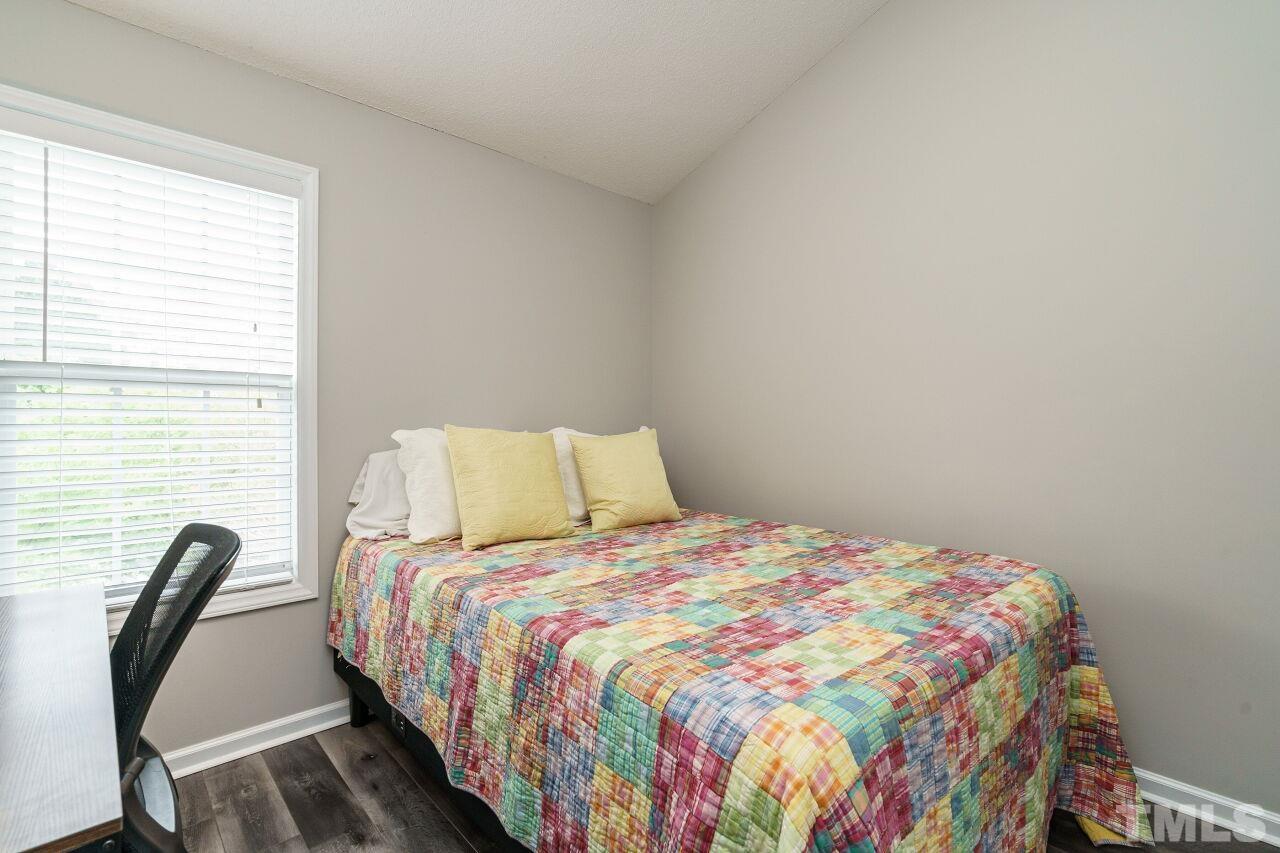 6903 Middleboro Drive Raleigh, NC 27612 - Photo 19 of 26 a bedroom with a bed a chair and a potted plant