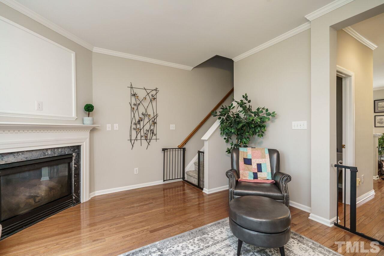 6903 Middleboro Drive Raleigh, NC 27612 - Photo 8 of 26 a living room with furniture a fireplace and potted plant