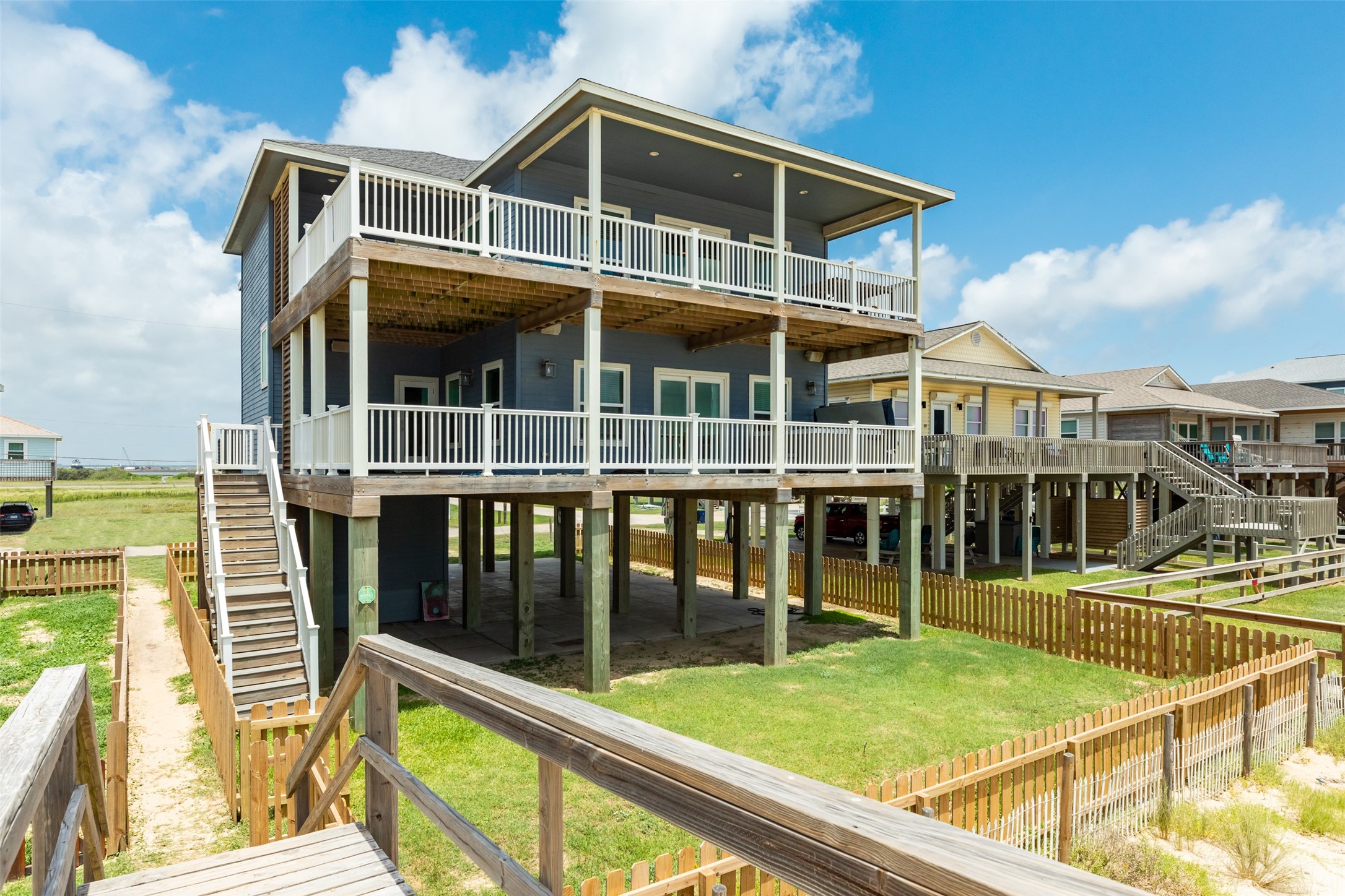 109 A Santar Loop, Unit A Surfside Beach, TX 77541 - Photo 14 of 43 Elevated coastal home with spacious decks, offering stunning views. Features an open layout, ample outdoor space, and a fenced yard. Ideal for beachside living.
