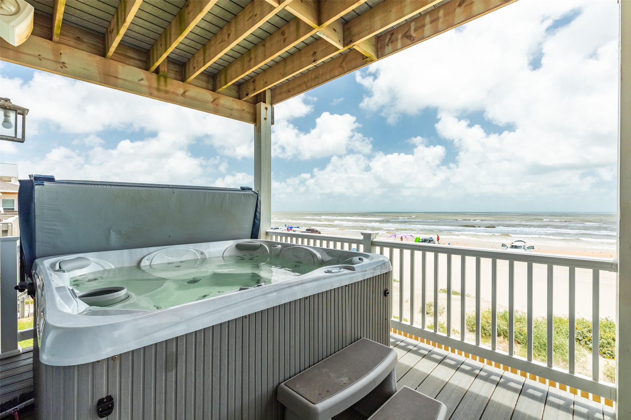 109 A Santar Loop, Unit A Surfside Beach, TX 77541 - Photo 17 of 43 This beachfront property features a covered deck with a hot tub, offering stunning ocean views and direct access to the sandy beach below. Perfect for relaxation and enjoying seaside living.