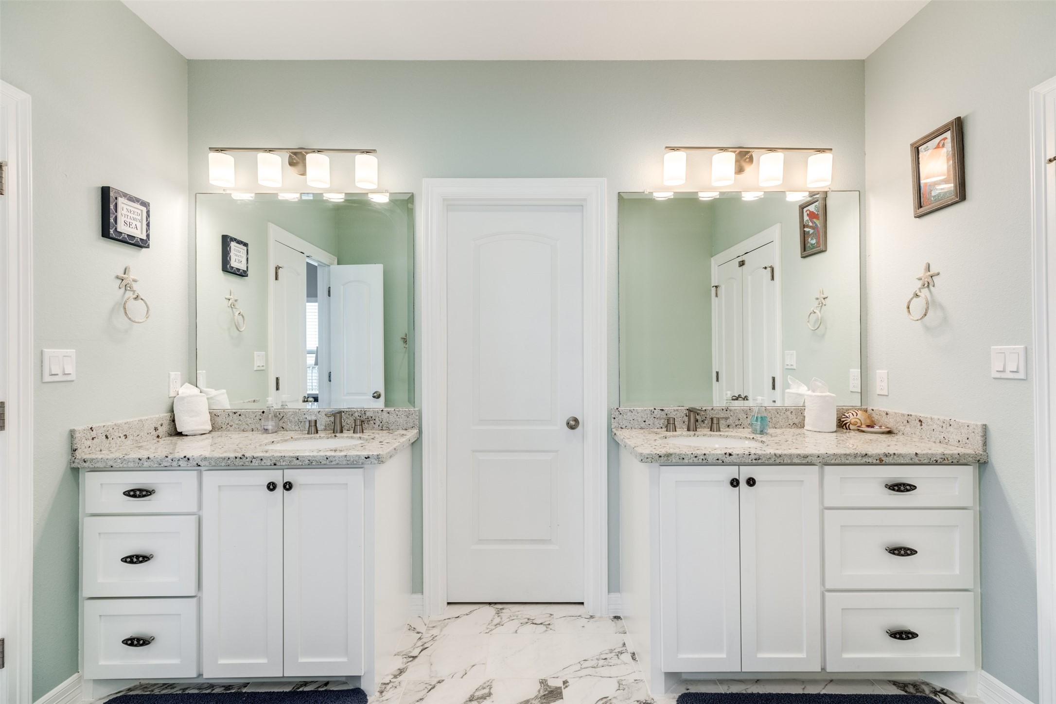109 A Santar Loop, Unit A Surfside Beach, TX 77541 - Photo 26 of 43 This bathroom features a dual-sink vanity with granite countertops and elegant fixtures. It has a clean, modern design with ample storage and bright lighting, creating a fresh and inviting space.